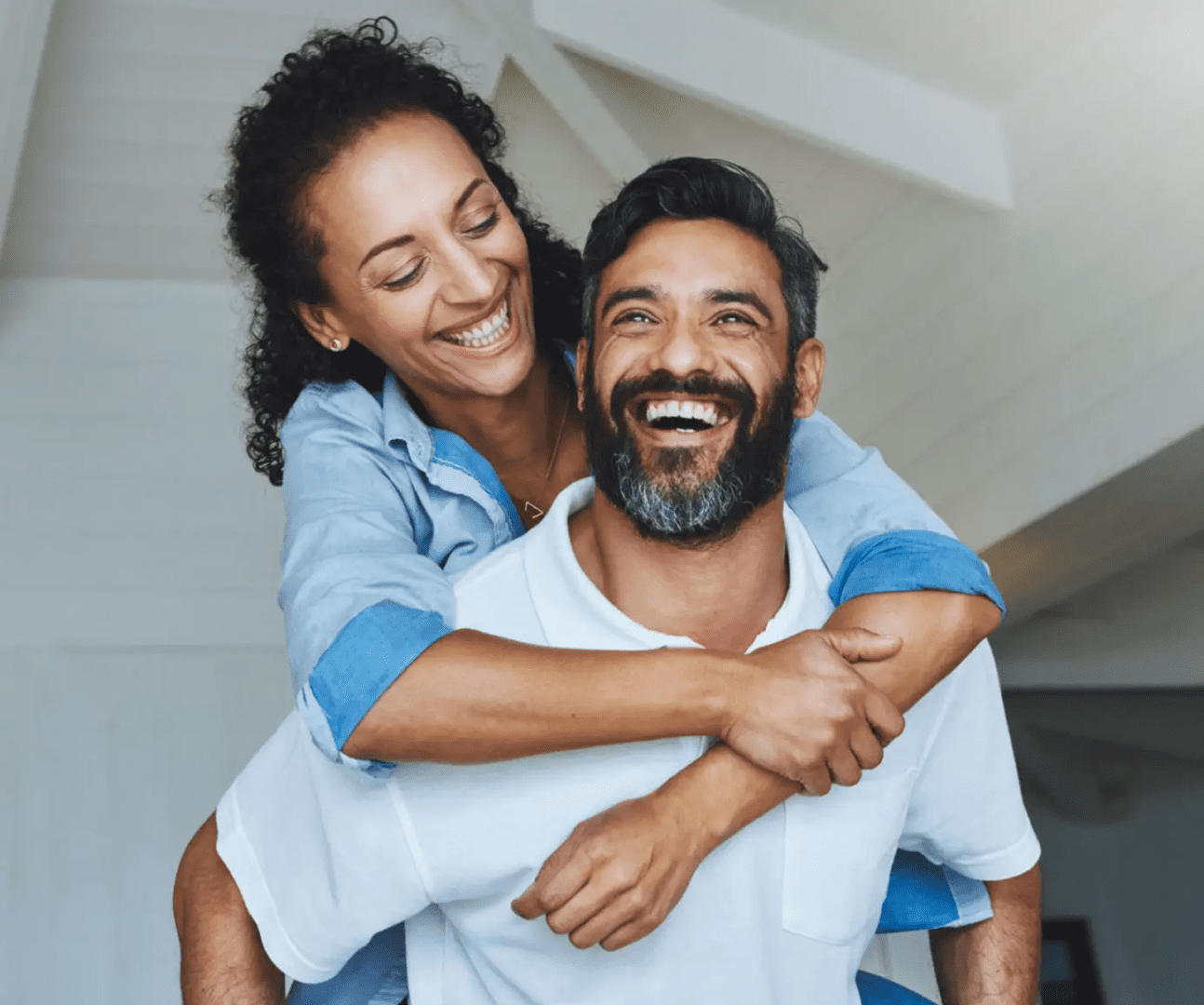 Smiling couple enjoying piggyback hug