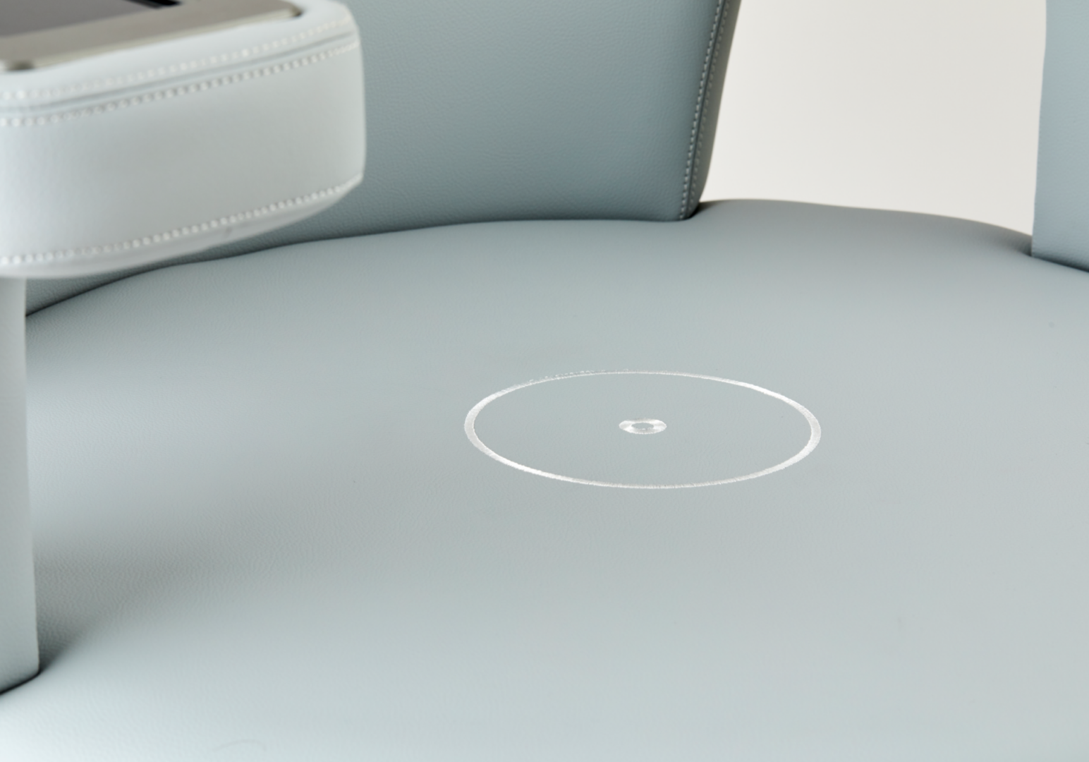 Light gray leather chair seat with circular mark