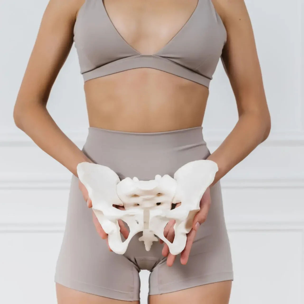 Woman holding pelvic bone model